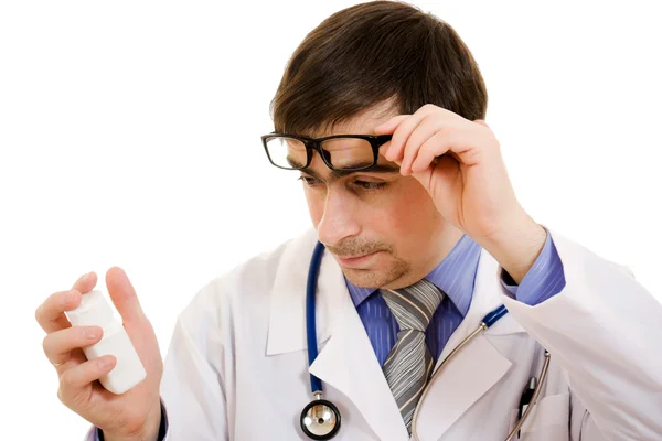 El médico que sostiene un recipiente de vitaminas sobre un fondo blanco . — Foto de Stock