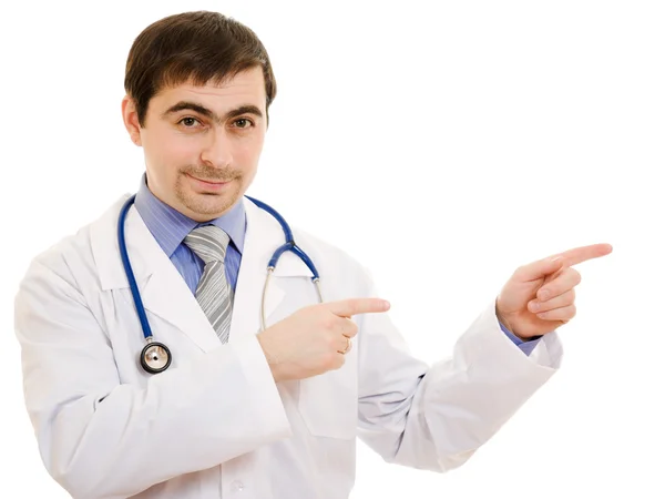 Médico masculino aponta o dedo na direção de um fundo branco . — Fotografia de Stock