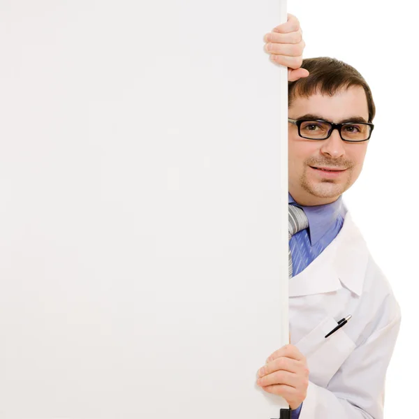 Male doctor with a white board on a white background. — Stock Photo, Image
