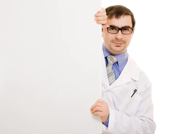 Male doctor with a white board on a white background. — Stock Photo, Image