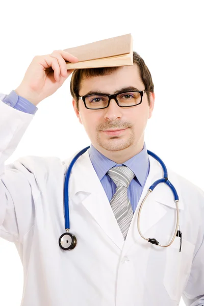 Ο γιατρός με ένα βιβλίο στο κεφάλι του σε λευκό φόντο. — Φωτογραφία Αρχείου