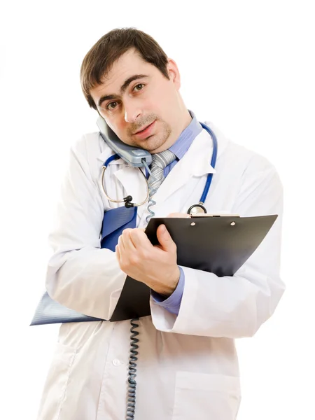 Male doctor talking on the phone and writing on the document plate on a whi Stock Photo