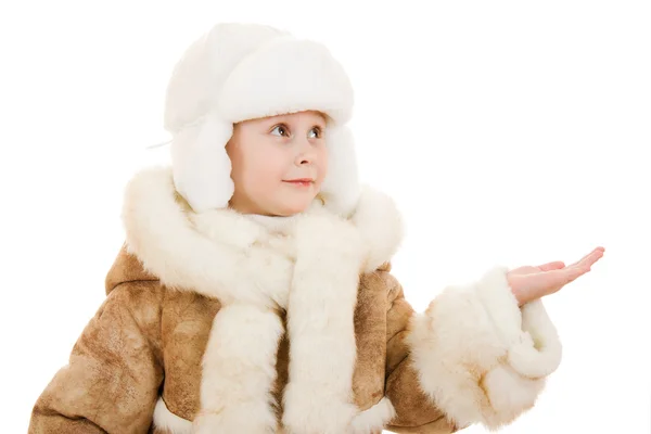 Girl in a sheepskin coat and hat with an open palm on a white background. — Stock Photo, Image