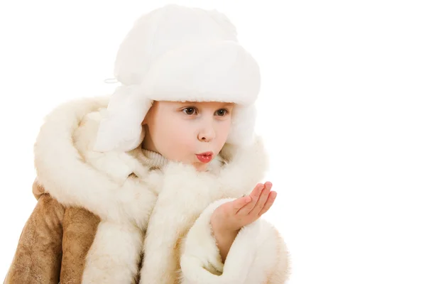 Menina em um casaco de pele de carneiro e boné envia um beijo em um fundo branco . — Fotografia de Stock