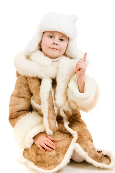 Het meisje in warme kleren wijst een vinger omhoog op een witte achtergrond. — Stockfoto