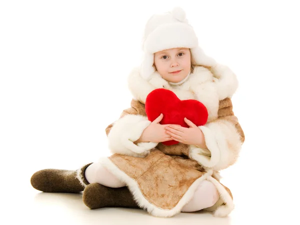 Menina em roupas quentes segurando o coração em suas mãos em um fundo branco . — Fotografia de Stock