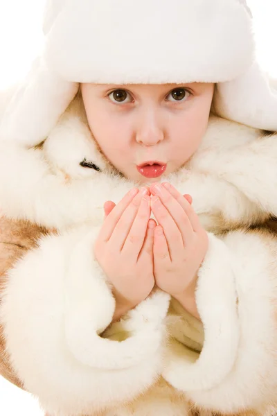 A menina em roupas quentes soprando em suas mãos em um fundo branco . — Fotografia de Stock