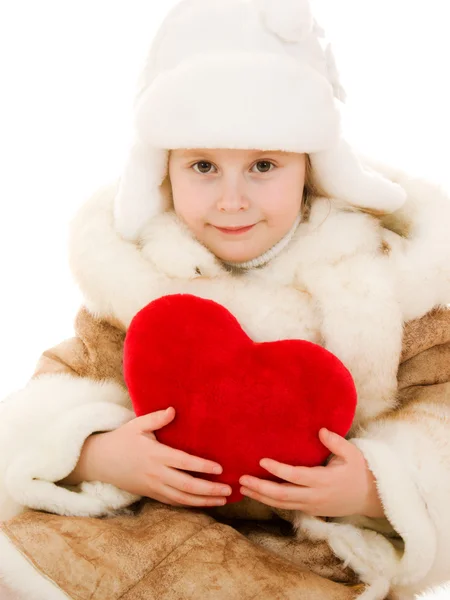 Dívka v teplé oblečení drží srdce v rukou na bílém pozadí. — Stock fotografie