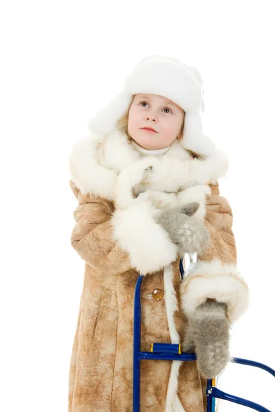 Το κορίτσι σε ζεστά ρούχα με μια έκπληξη sledge κοιτώντας ψηλά σε άσπρο φόντο. — Φωτογραφία Αρχείου