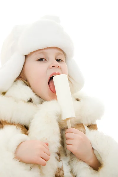 Девушка в теплой одежде ест мороженое на белом фоне . — стоковое фото