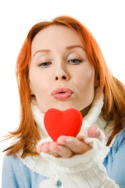 La ragazza manda un bacio aereo sotto forma di cuore su uno sfondo bianco . — Foto Stock