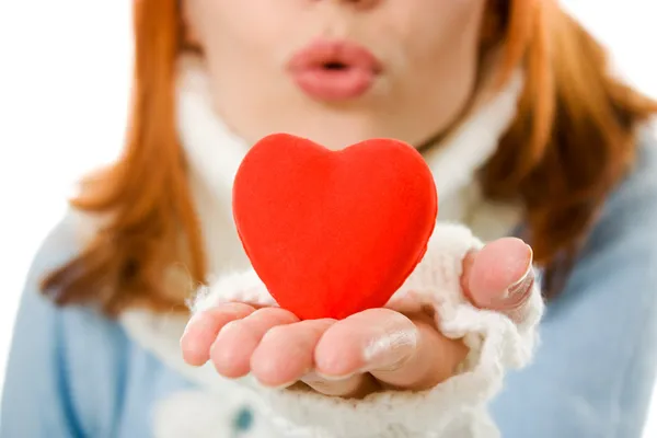 La ragazza manda un bacio aereo sotto forma di cuore su uno sfondo bianco . — Foto Stock