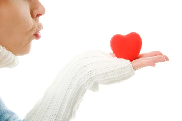 A menina envia um beijo de ar na forma de coração em um fundo branco . — Fotografia de Stock