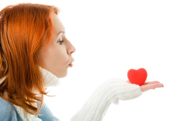 Het meisje stuurt een kus lucht in de vorm van hart op een witte achtergrond. — Stockfoto