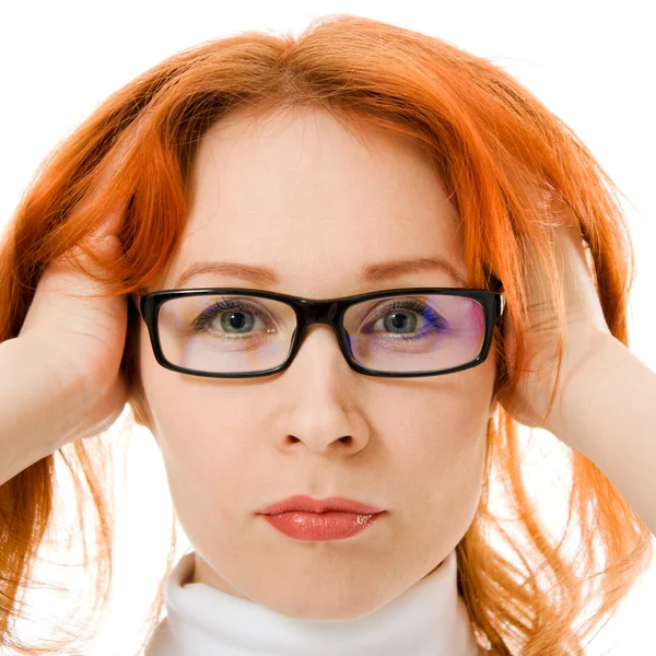 Ein schönes Mädchen mit roten Haaren trägt eine Brille auf weißem Hintergrund. — Stockfoto