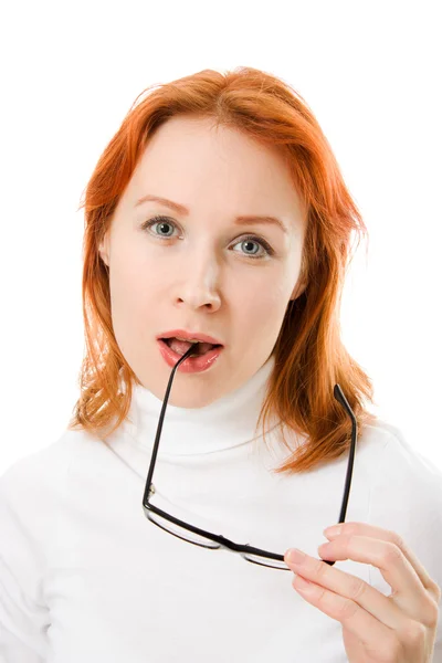 A beautiful girl with red hair wearing glasses thinking on a white background. — Stock Photo, Image