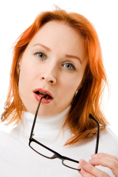 Una hermosa chica con el pelo rojo usando gafas pensando en un fondo blanco . — Foto de Stock