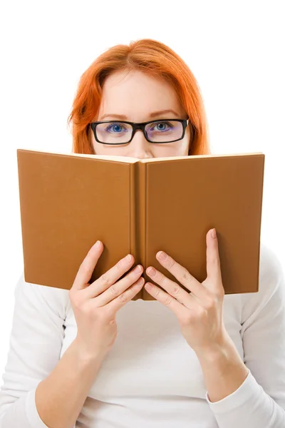 stock image Beautiful red-haired girl in glasses reads book.