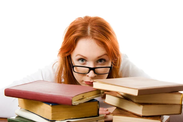 Vacker rödhårig flicka i glasögon läser bok. — Stockfoto
