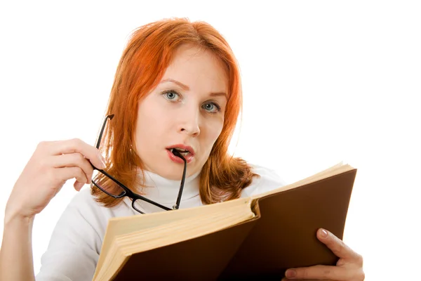 Krásná rusovlasá dívka v brýlích čte knihu. — Stock fotografie