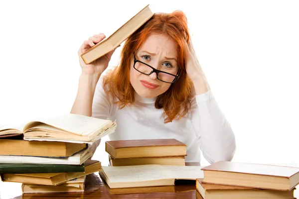 Gyönyörű vörös hajú lány szemüvegét elolvassa a könyvet. — Stock Fotó