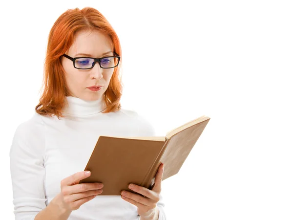 stock image Beautiful red-haired girl in glasses reads book.