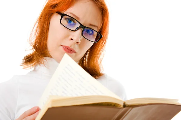 Beautiful red-haired girl in glasses reads book. — Stock Photo, Image