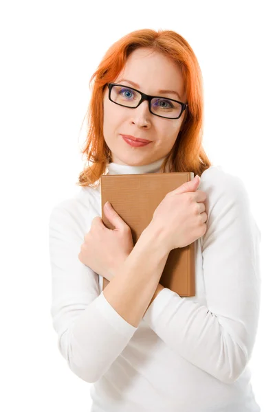 Schöne rothaarige Mädchen mit Brille liest Buch. Stockbild