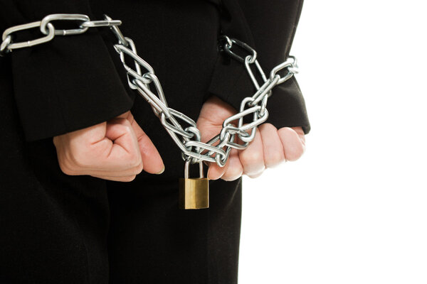 Businesswoman with hands shackled in chains.