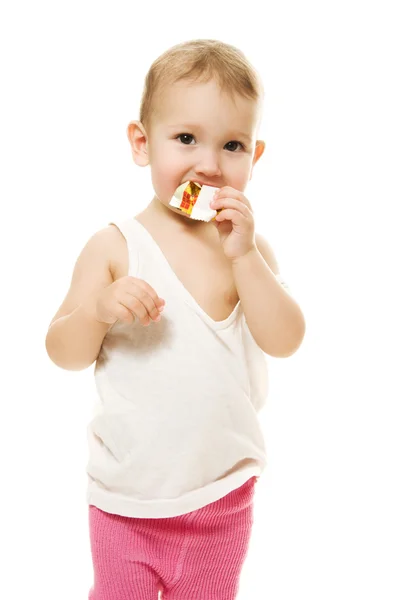 Bambino mangia caramelle su uno sfondo bianco — Foto Stock
