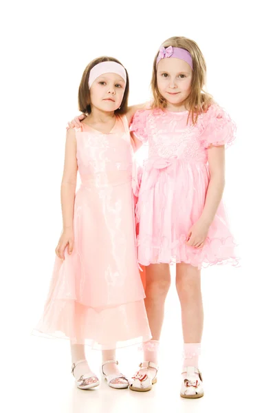 Two girlfriends hugging dresses in pink — Stock Photo, Image