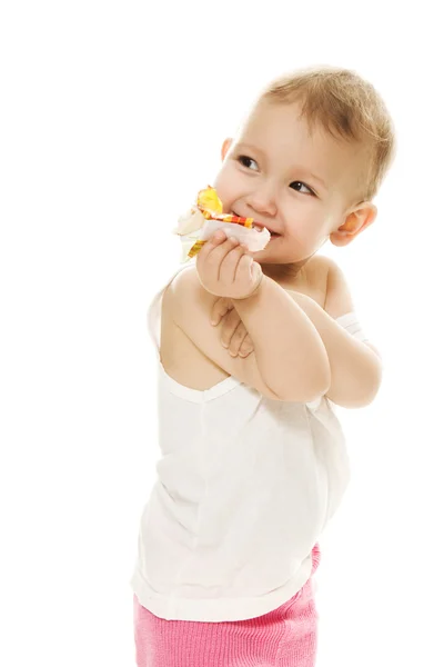 Bebê come doces em um fundo branco — Fotografia de Stock