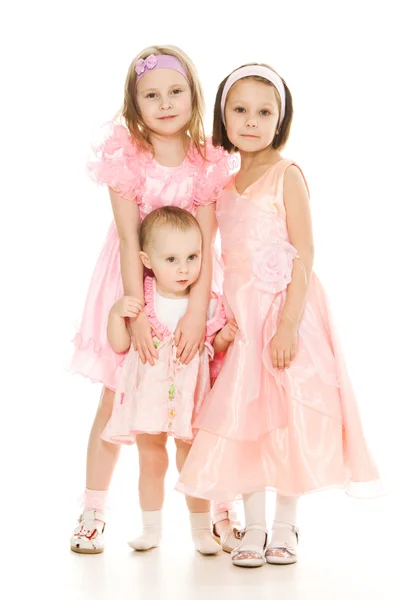 Three girlfriends in pink dresses hug — Stock Photo, Image