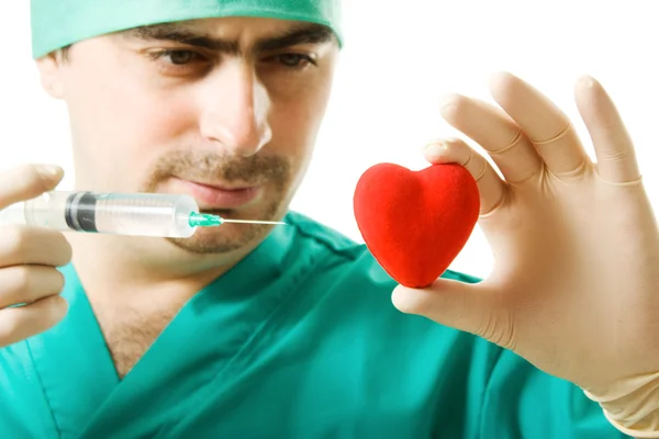 Lekarz z sercem i strzykawki w ręku — Zdjęcie stockowe