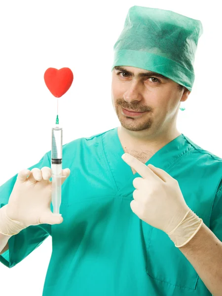 Médico varón con un corazón y una jeringa en la mano sobre un fondo blanco . —  Fotos de Stock