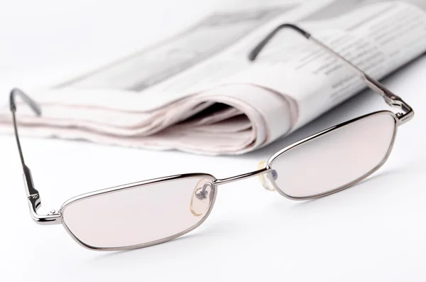 Eyeglass and newspaper — Stock Photo, Image