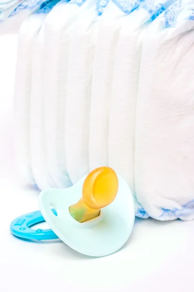 The pile of diapers and baby's dummy — Stock Photo, Image