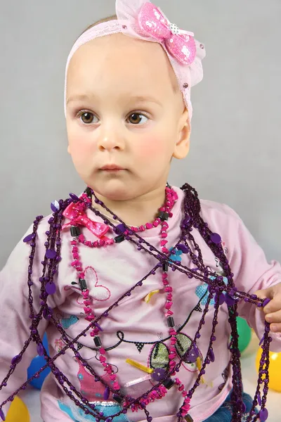 The little girl tries on a beads — Stock Photo, Image