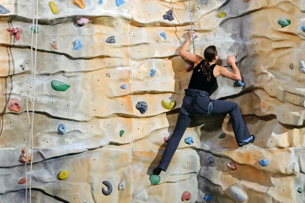 Woman on rock wall in sport centre — Stock Photo, Image