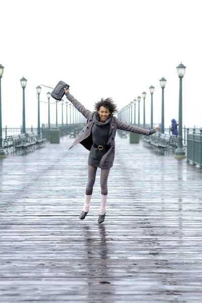 Pretty African American girl jumping on the pier — Stock Photo, Image