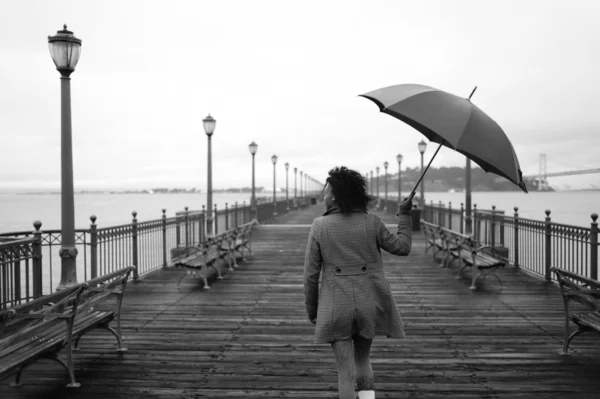 Девушка ходит с зонтиком — стоковое фото