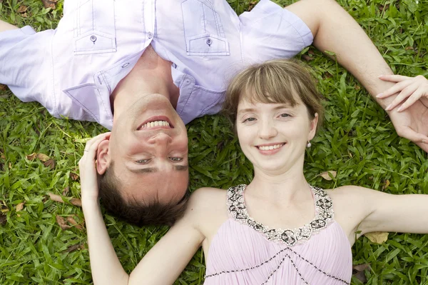 Jeune couple couché sur l'herbe — Photo