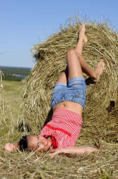 Woman lie near haystack — Stock Photo, Image