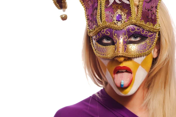 Woman in violet mask with blue pill on tongue — Stock Photo, Image