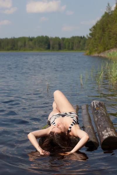 Das Mädchen sonnt sich auf einem Floß — Stockfoto