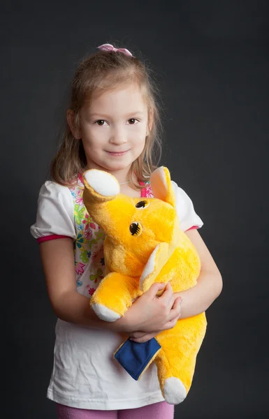 Girl with a yellow elephant — Stock Photo, Image
