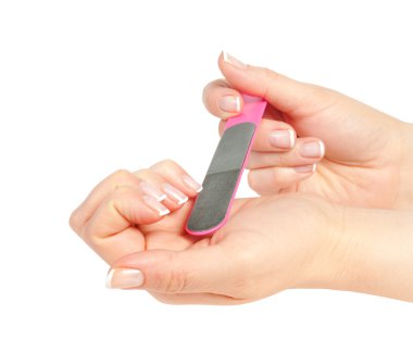 Woman files her nails by emery board from manicure set