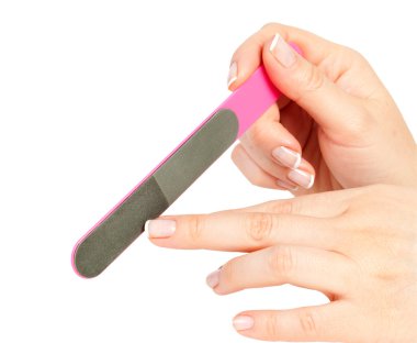 Woman files her nails by emery board from manicure set