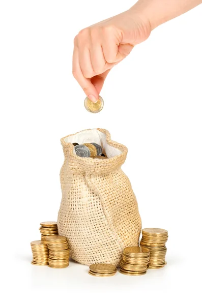 Mão colocar moeda no saco com dinheiro — Fotografia de Stock