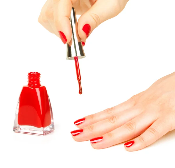 Manicurista aplicando esmalte de uñas rojo en dedos femeninos — Foto de Stock